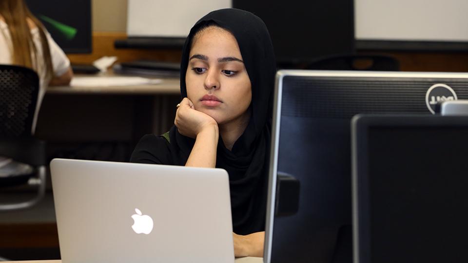 A student stares at a computer screen.