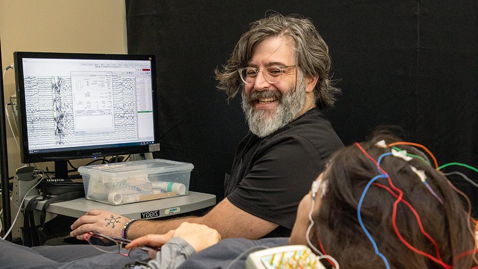 a man working with a patient and a computer program to practice Neurodiagnostic Technology techniques