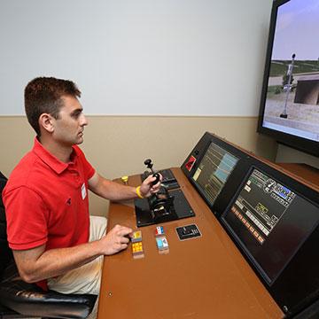 A student works in a railroad simulator.